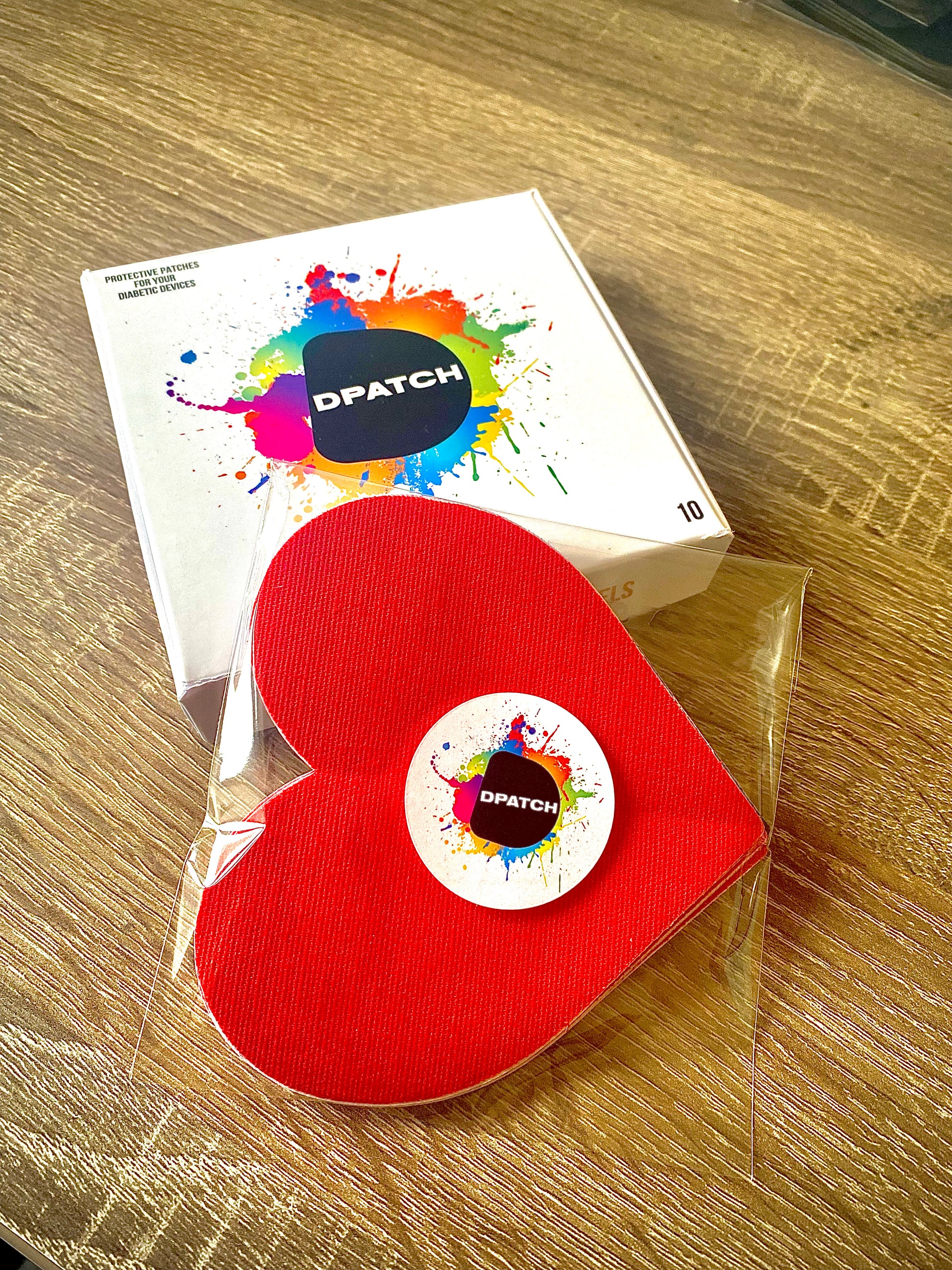 Red heart-shaped product with DPATCH logo on a wooden surface-simplera